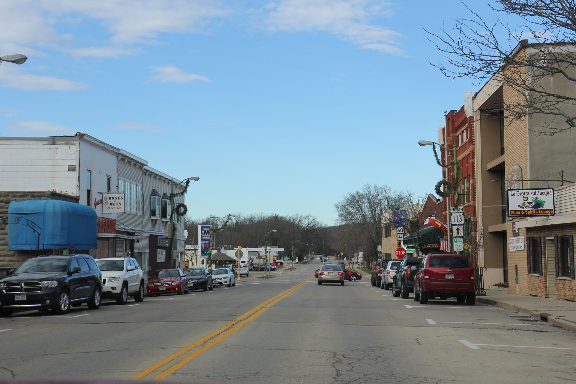Street view of Lodi with cars parked on both sides of the road and buildings lining the street.