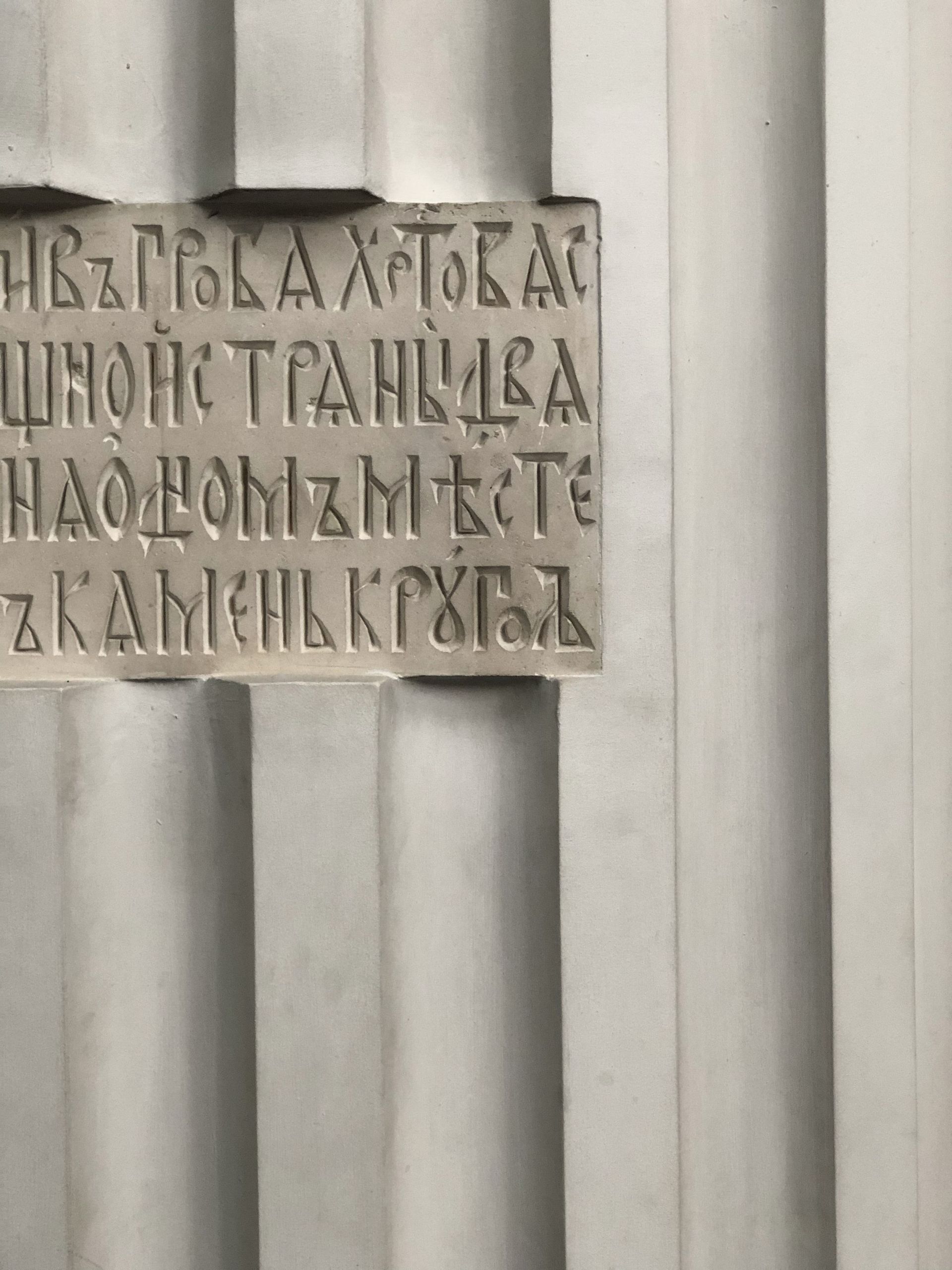 Stone wall with a small carved plaque of Cyrillic text in the center