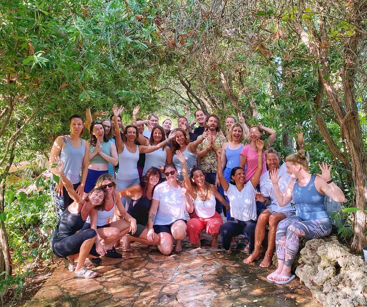 Yoga retreat participants gathered beneath olive trees in Corfu