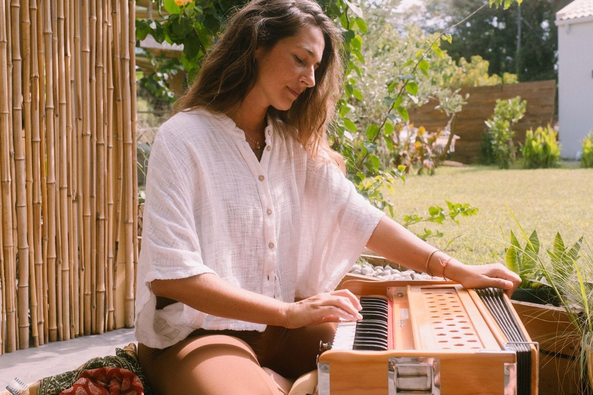 Yoga teacher Athina playing harmonium during a mantra practice in Corfu