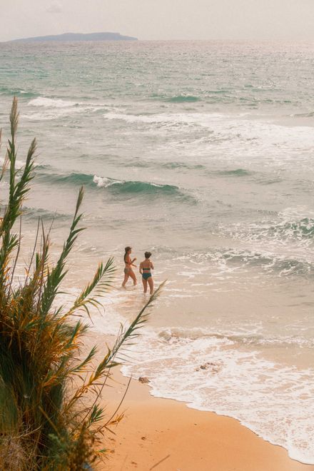 Guests walking along a sandy beach near the yoga retreat centre in Corfu