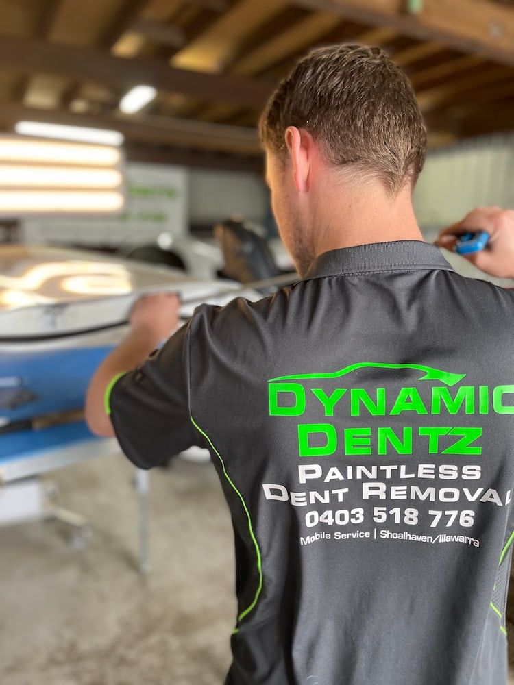 A man in a workshop is wearing a Dynamic Dentz Smash Repair work shirt — Dynamic Dentz Smash Repair in South Nowra, NSW