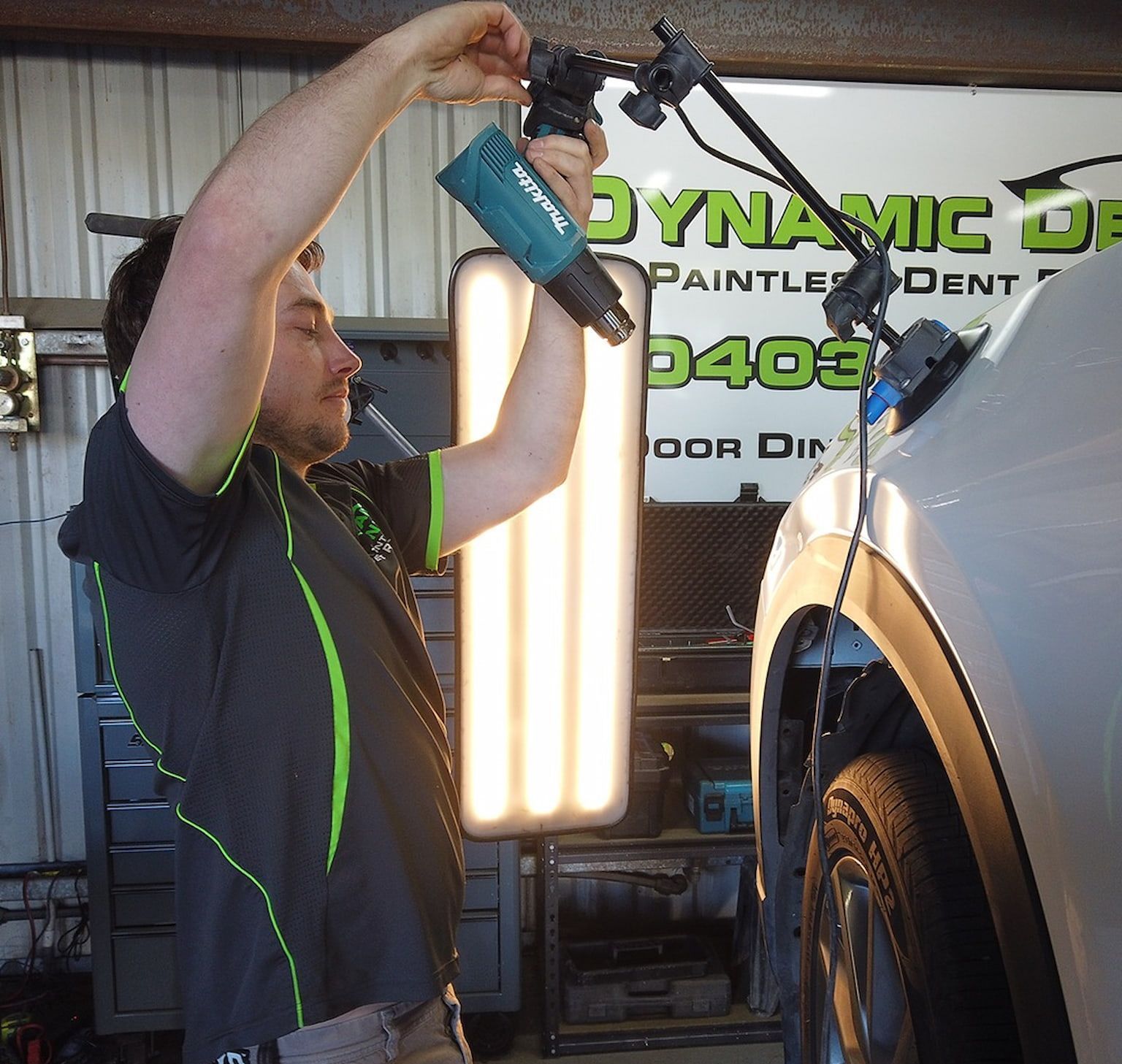 A Blue Car is Sitting on a Lift in a Garage — Dynamic Dentz Smash Repair in South Nowra, NSW