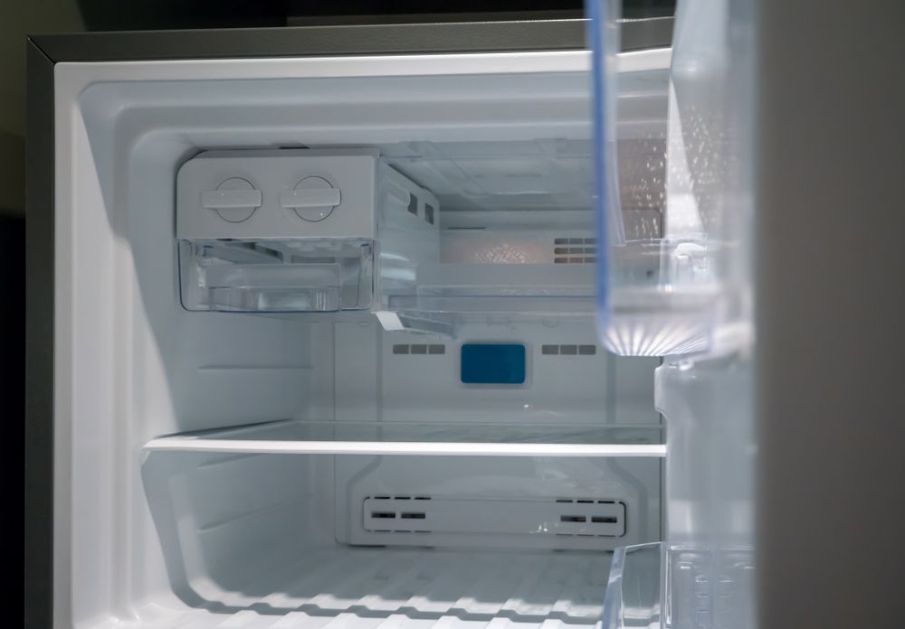 Empty Refrigerator Interior, With Ice Maker in the Top, Shelves, and Partially Open Door — SealTite in Tweed Heads, NSW