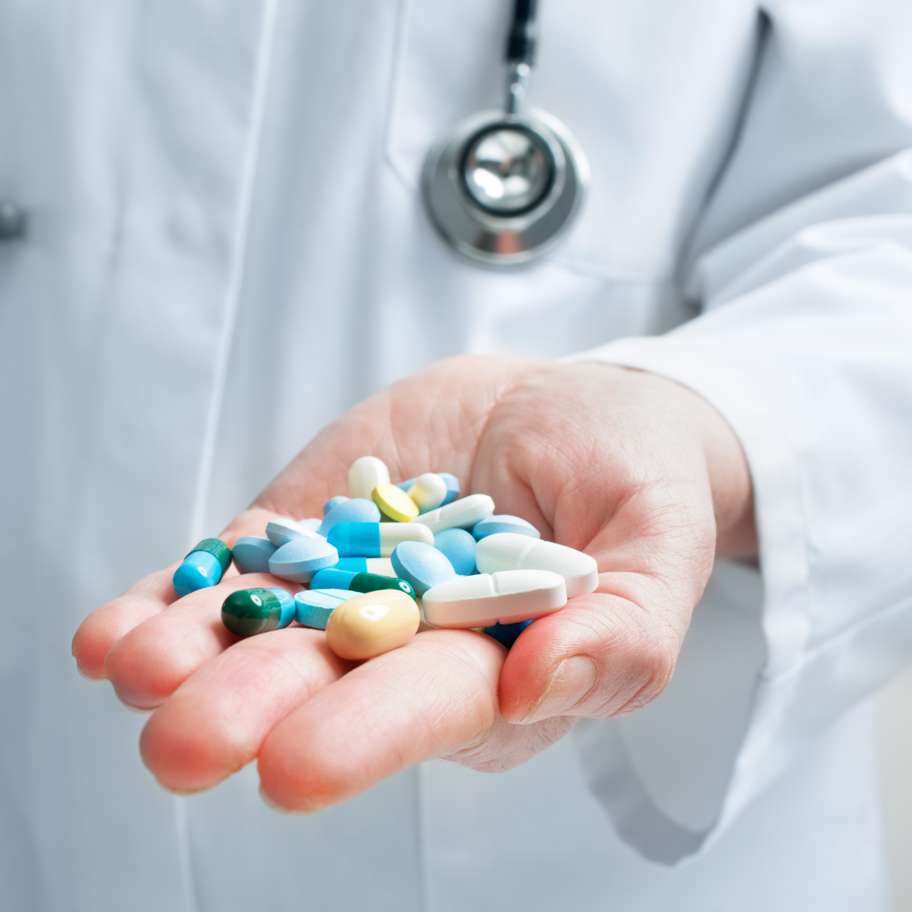 Doctor holding assorted pills in an open hand