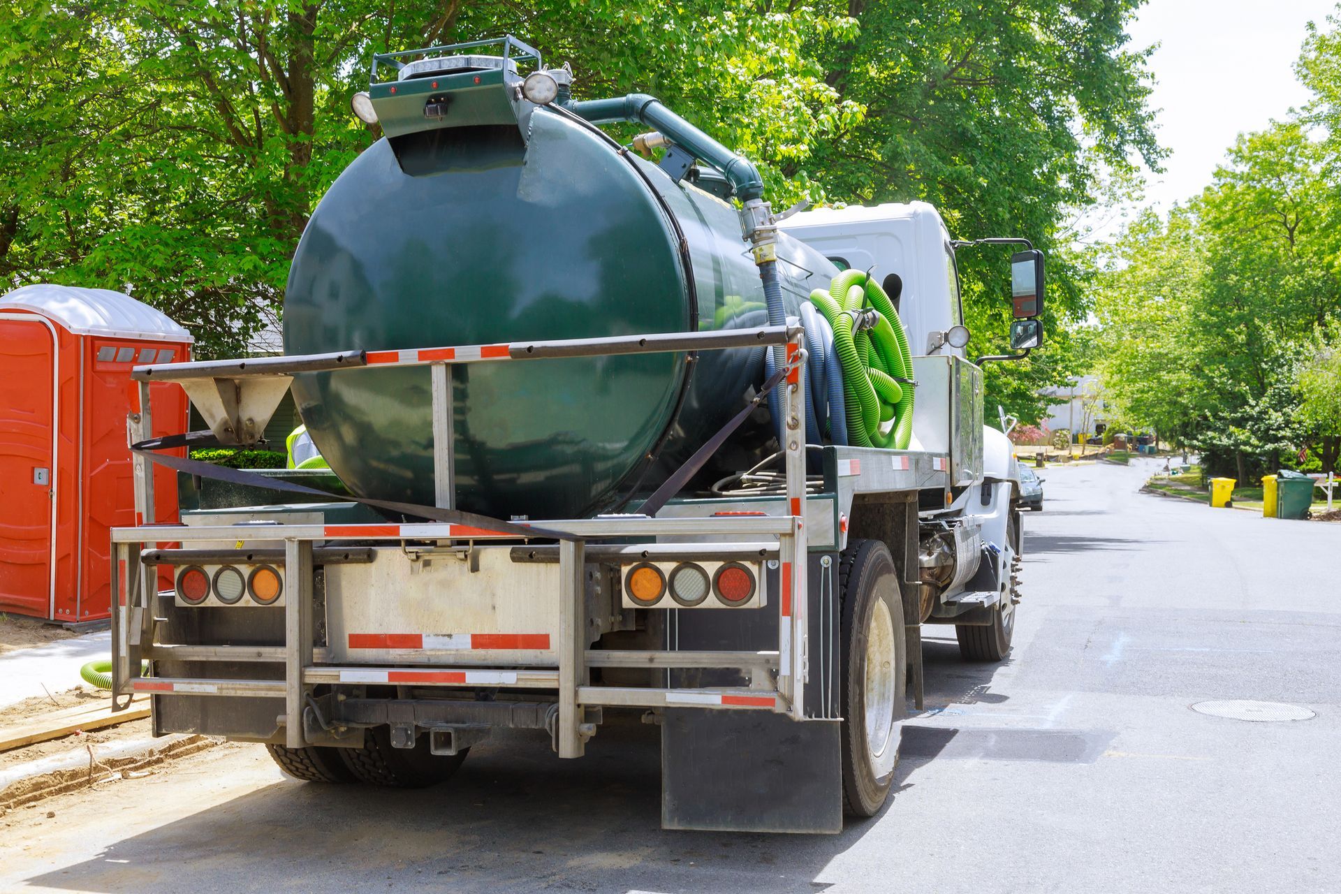 A vacuum truck is parked on the side of the road.