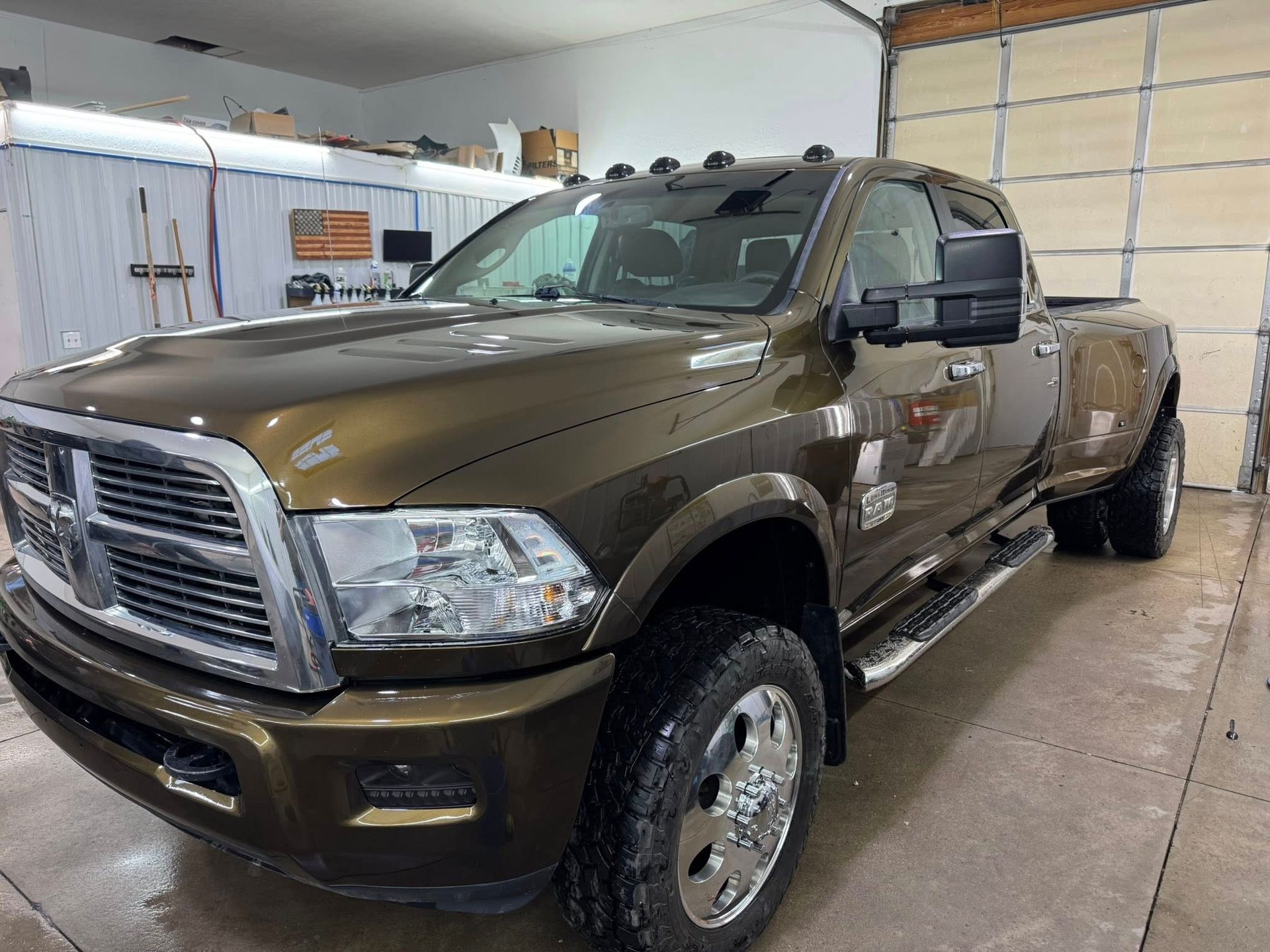 A bronze Ram dually pickup truck parked inside a garage.