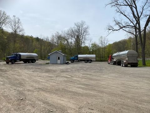 Several tanker trucks parked on a gravel lot