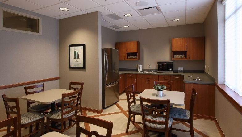 a room with tables and chairs and a picture on the wall .