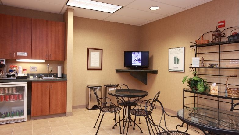 a room with tables and chairs and a picture on the wall .