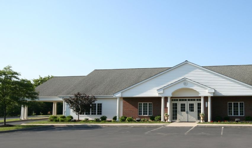 A newcomer bank building with a sign in front of it