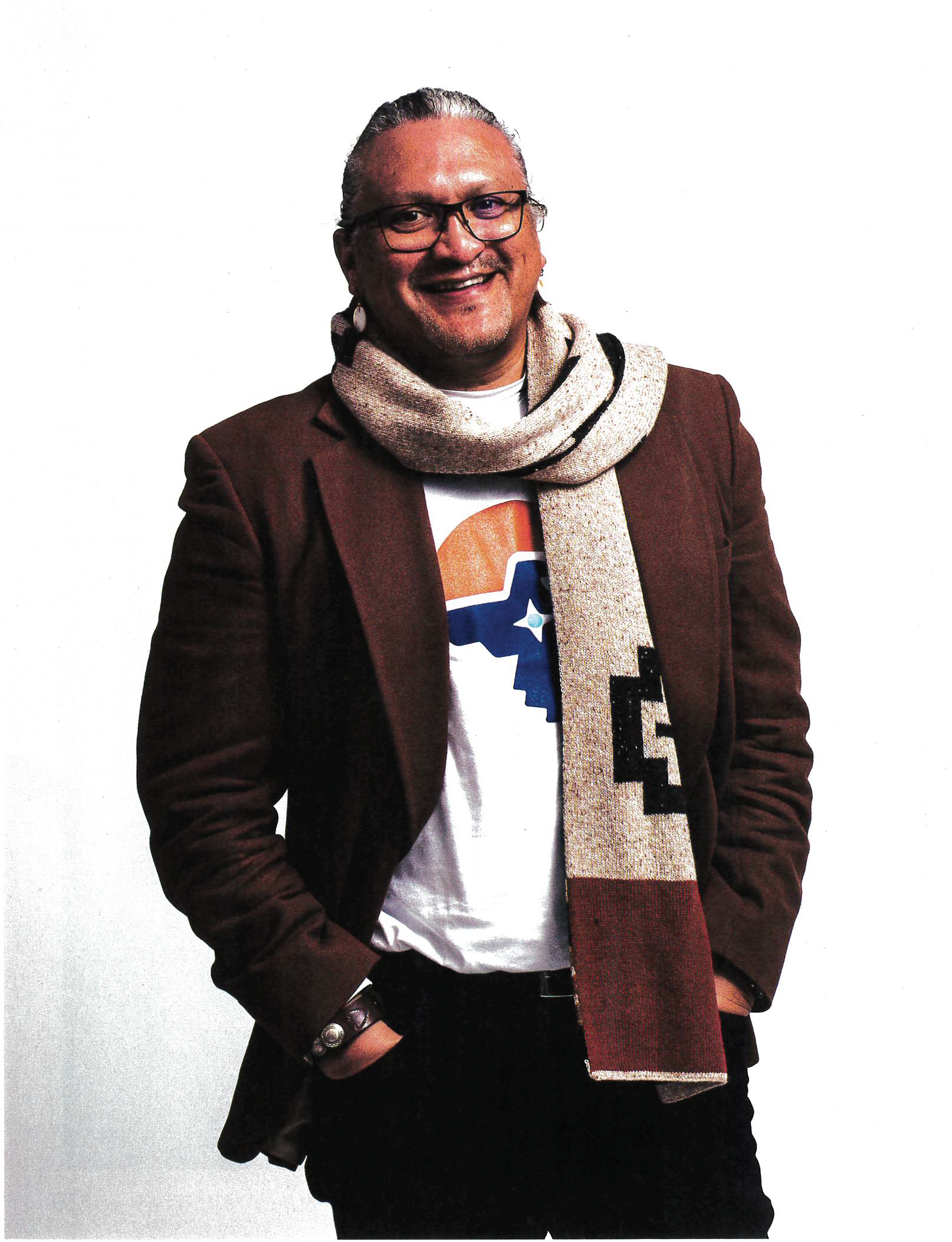 A man wearing glasses and a scarf with the letter l on it
