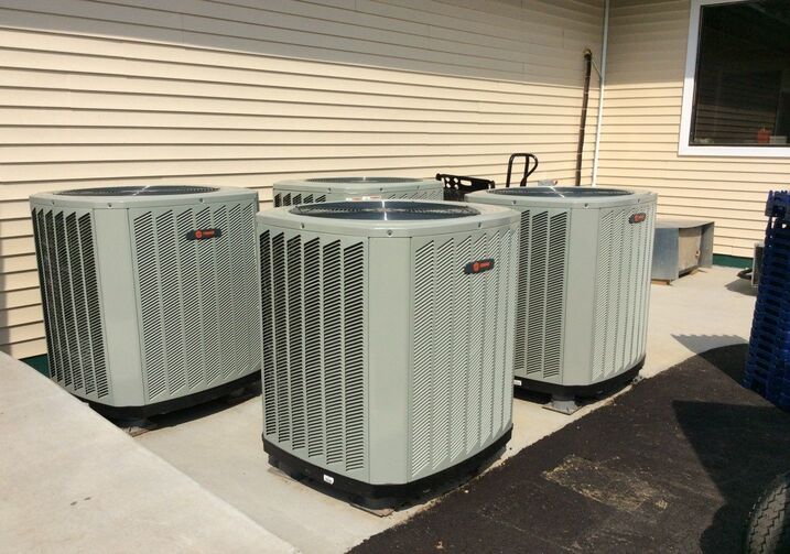 Three air conditioners are sitting outside of a building