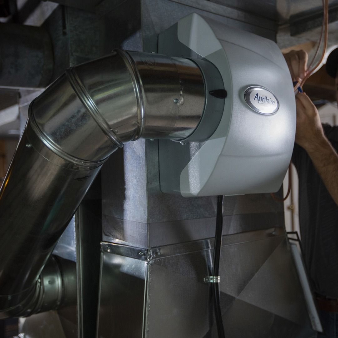 A man is working on a ventilation system in a building