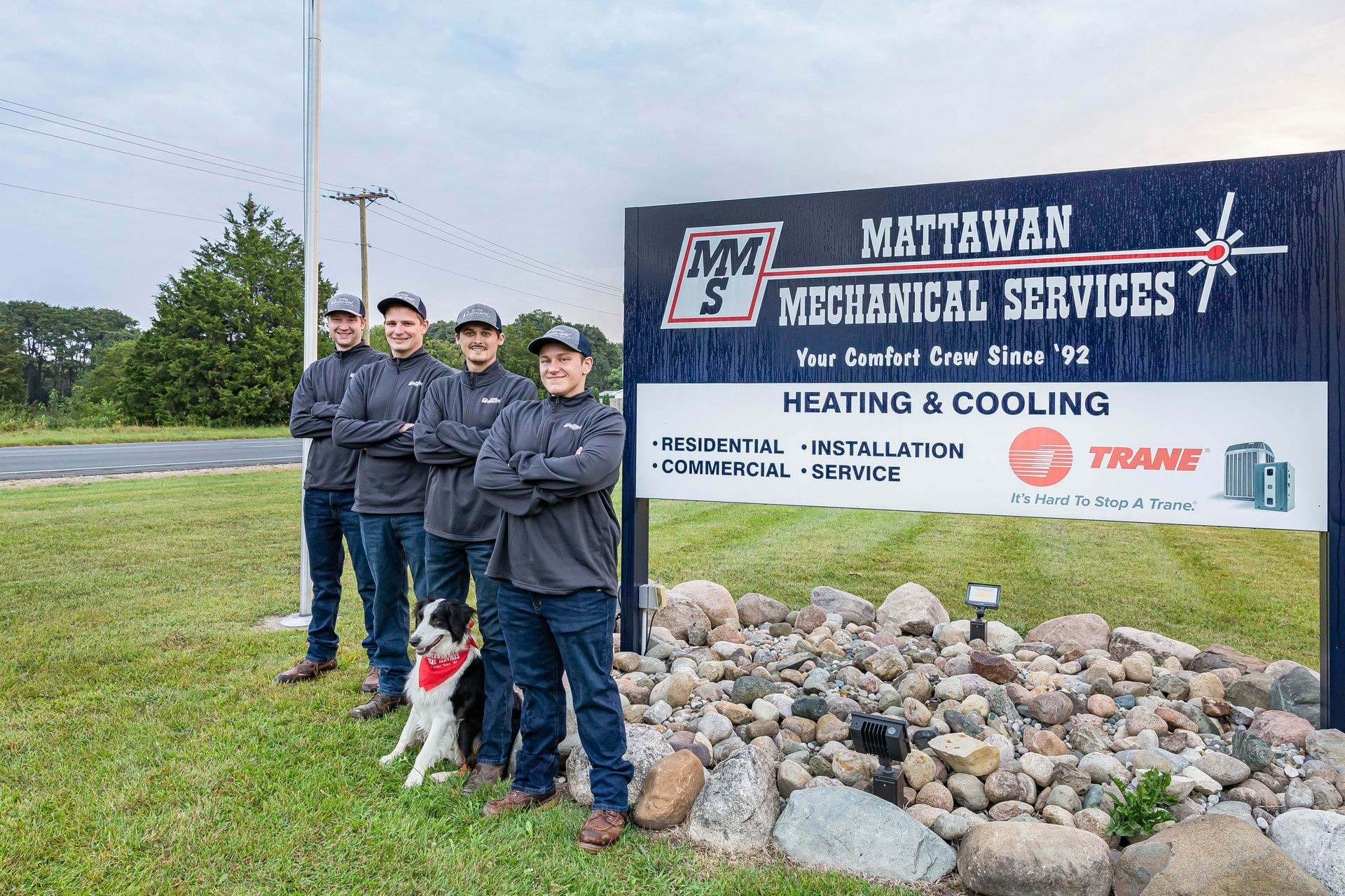 A group of men standing in front of a sign that says heating & cooling