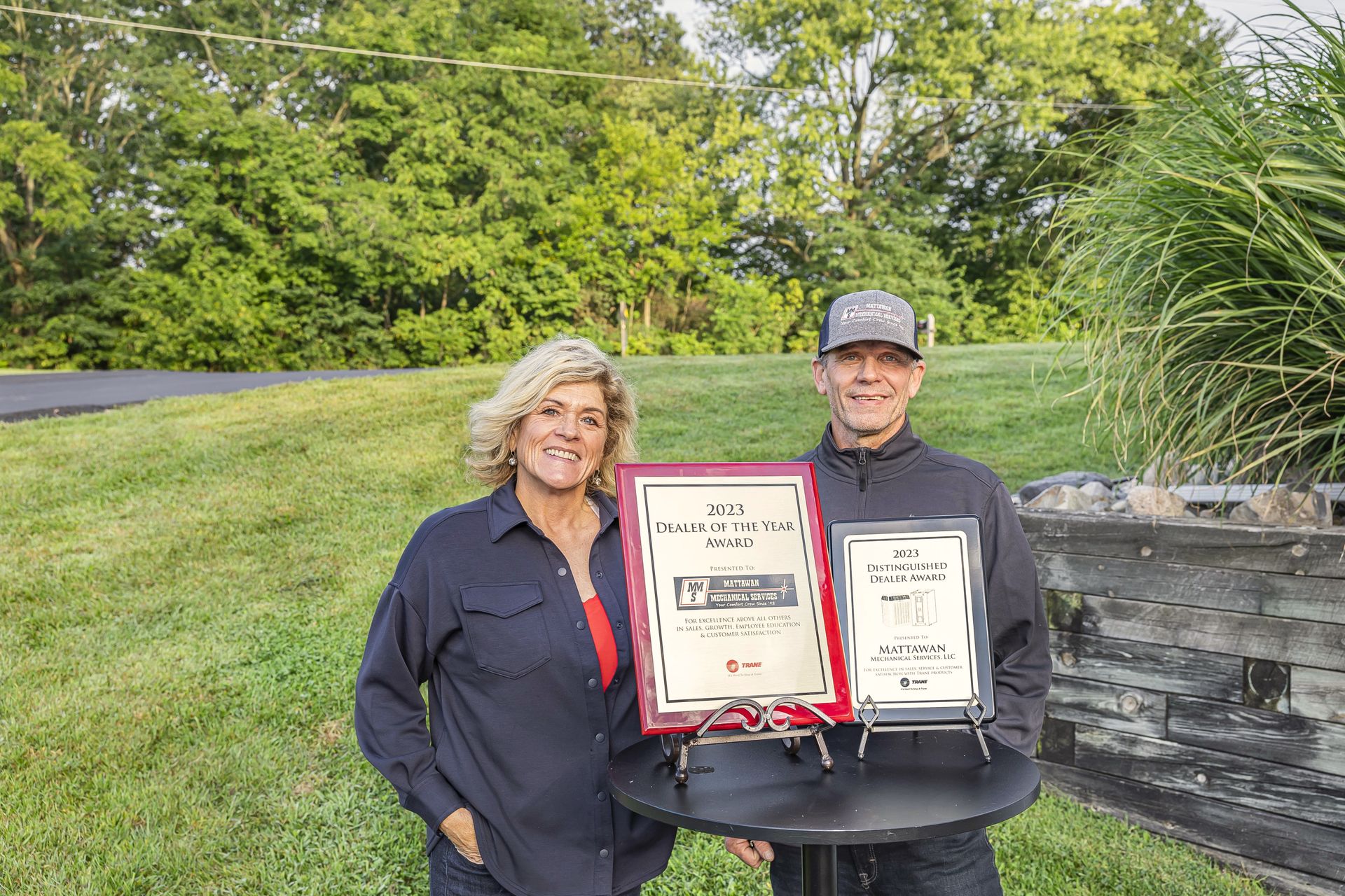 A man and a woman standing next to each other holding a certificate