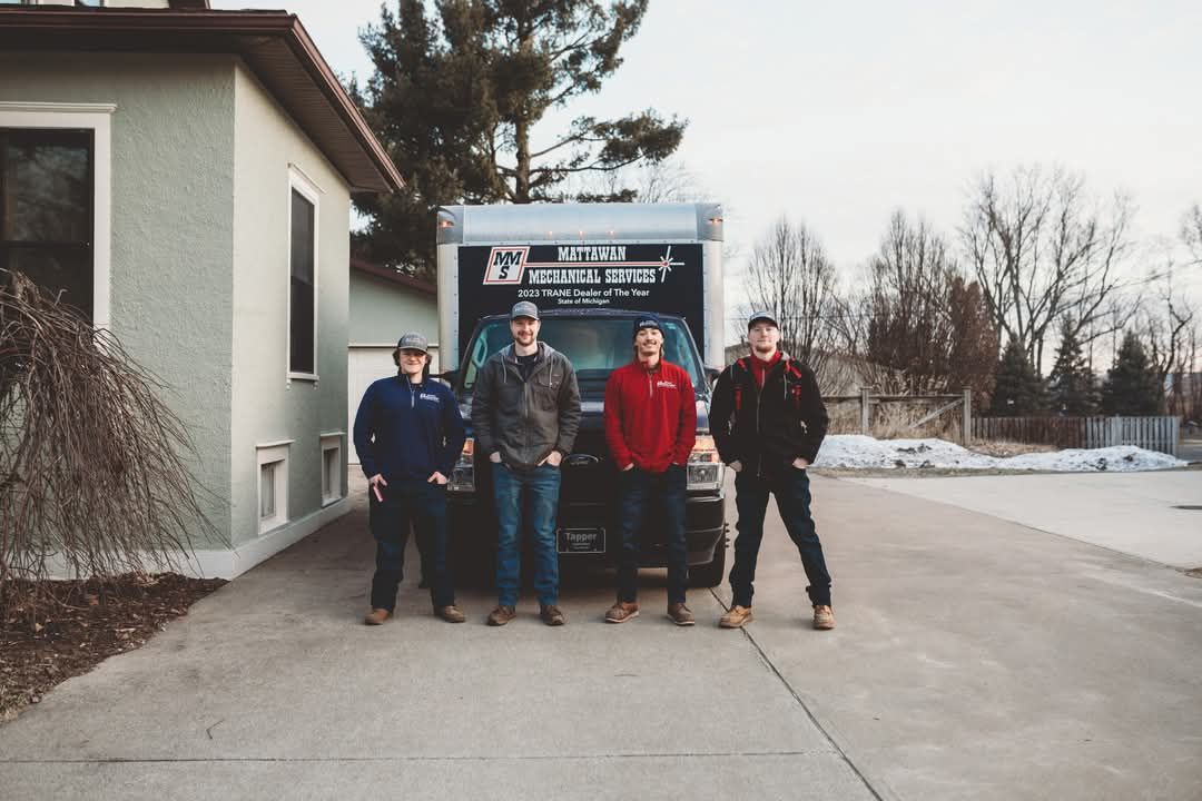 A group of men are standing in front of a truck.