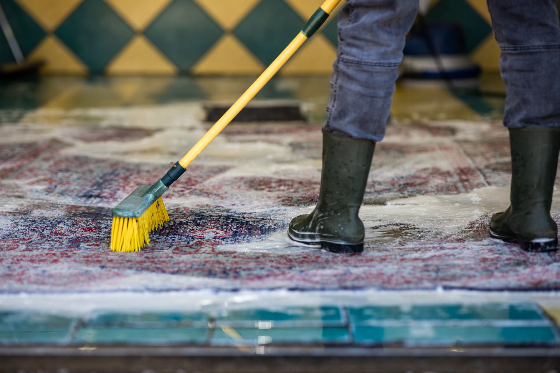 A person is cleaning an area rug.