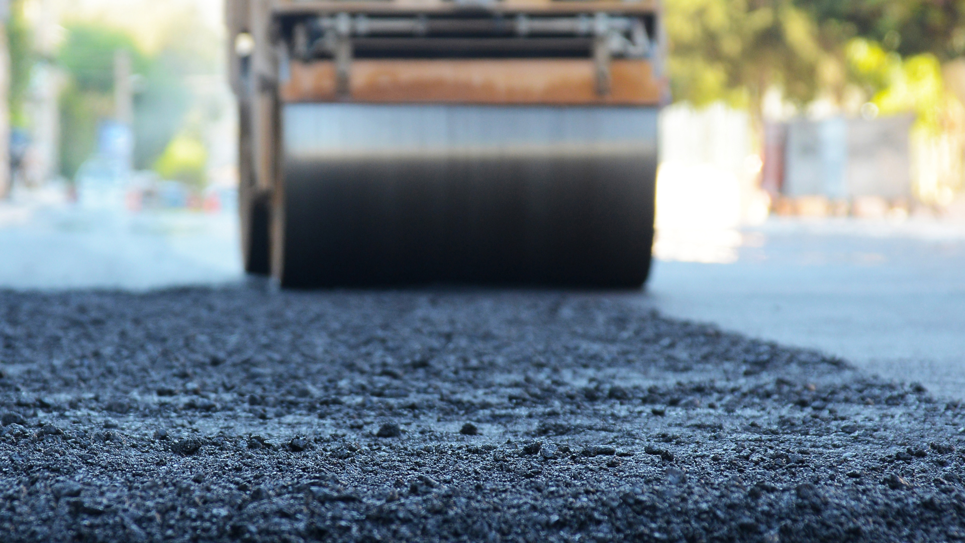 A roller is rolling asphalt on a road.