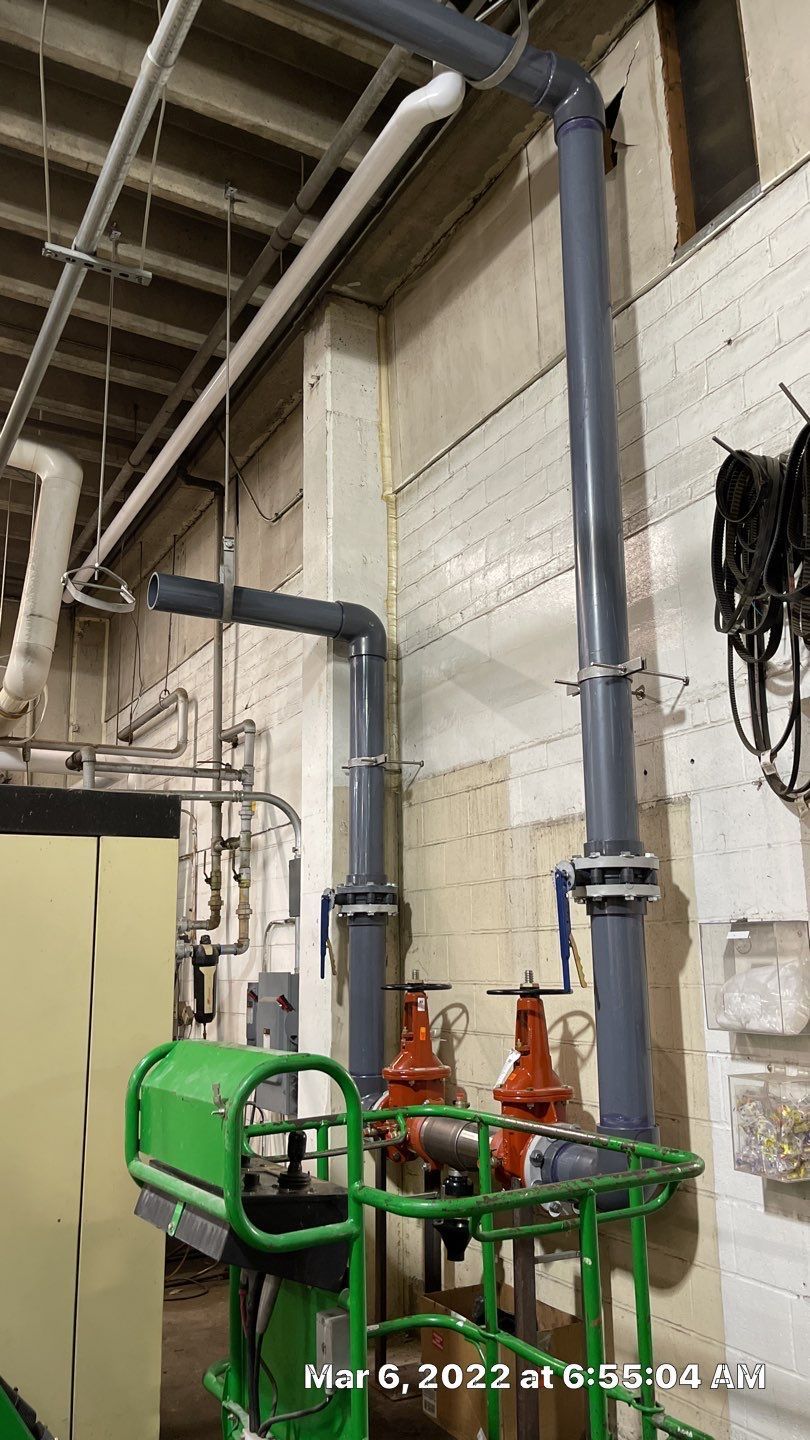 A room with a lot of pipes and valves on the wall.