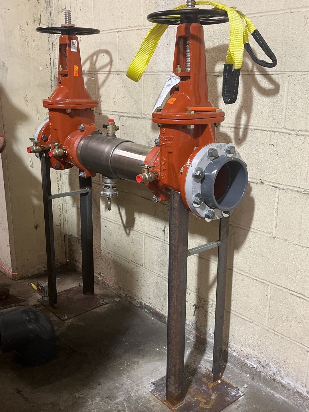 Two red valves are sitting next to each other in a room.