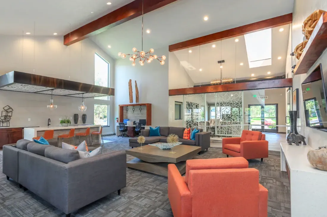 Modern lobby lounge area with sectional sofa, chairs, coffee table, and bar seating.