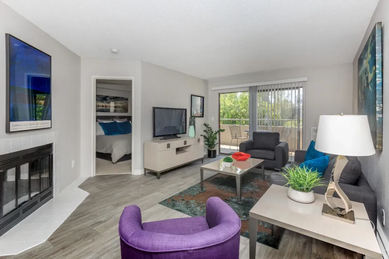 Living room with fireplace and view of bedroom.
