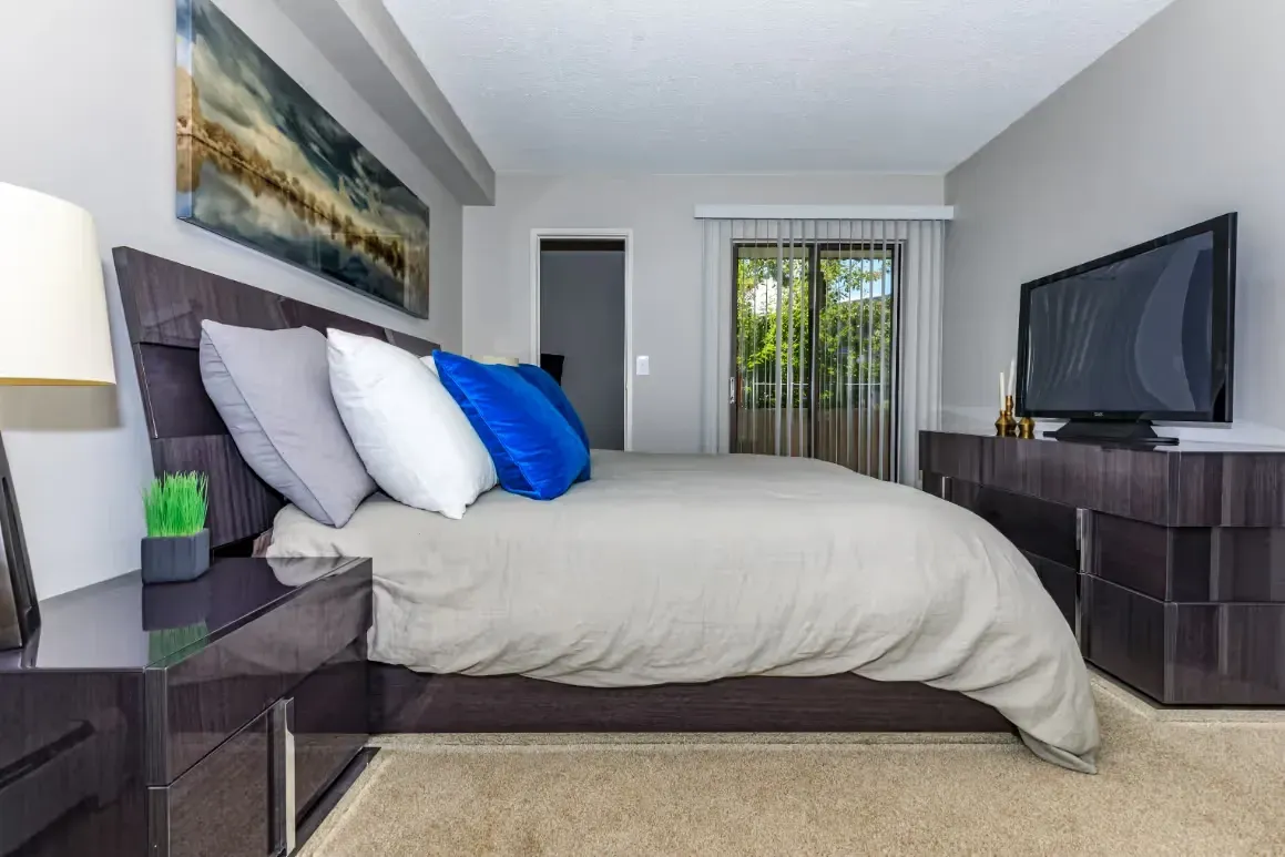 Bedroom with a king-size bed, nightstand, dresser, and TV.