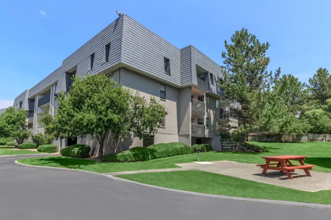 Exterior building view with a picnic table and green lawn.