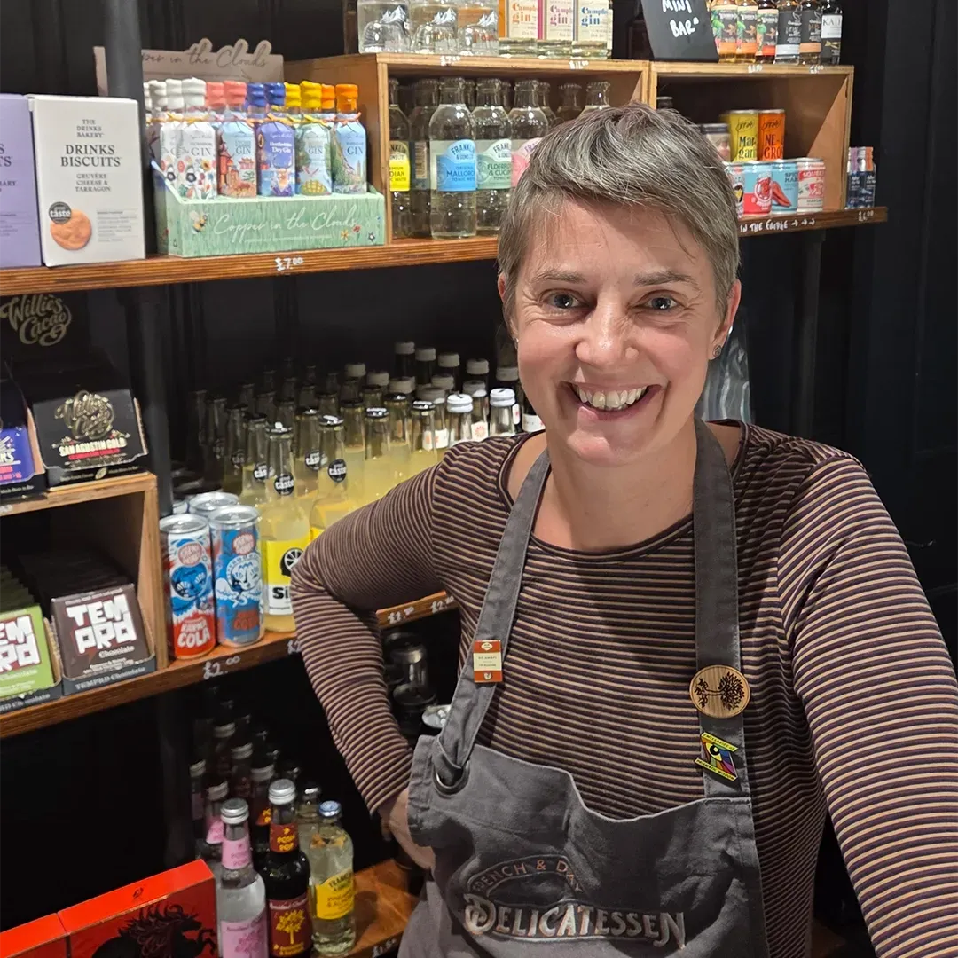 Kath smiles with an array of delicious food products behind her