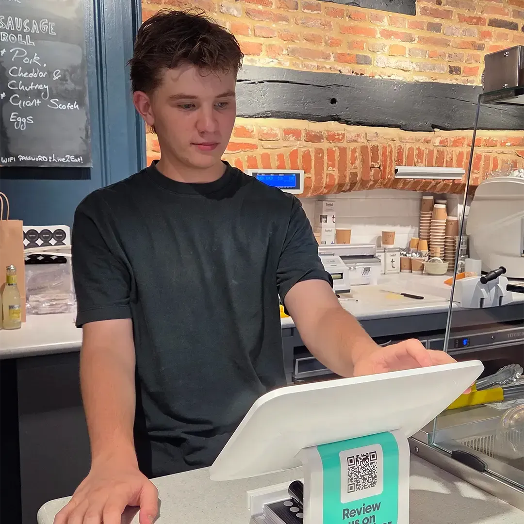 Reuben uses the till at French & Day Delicatessen