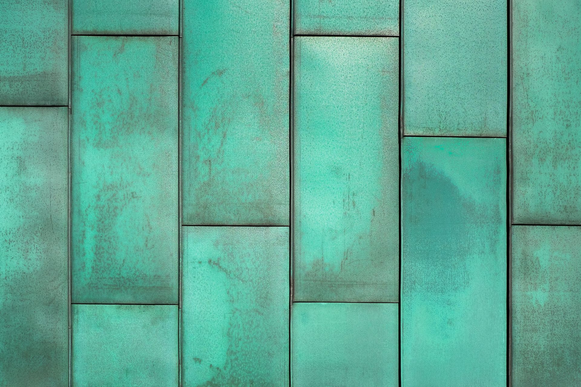 Turquoise weathered wooden panels arranged in a vertical geometric pattern