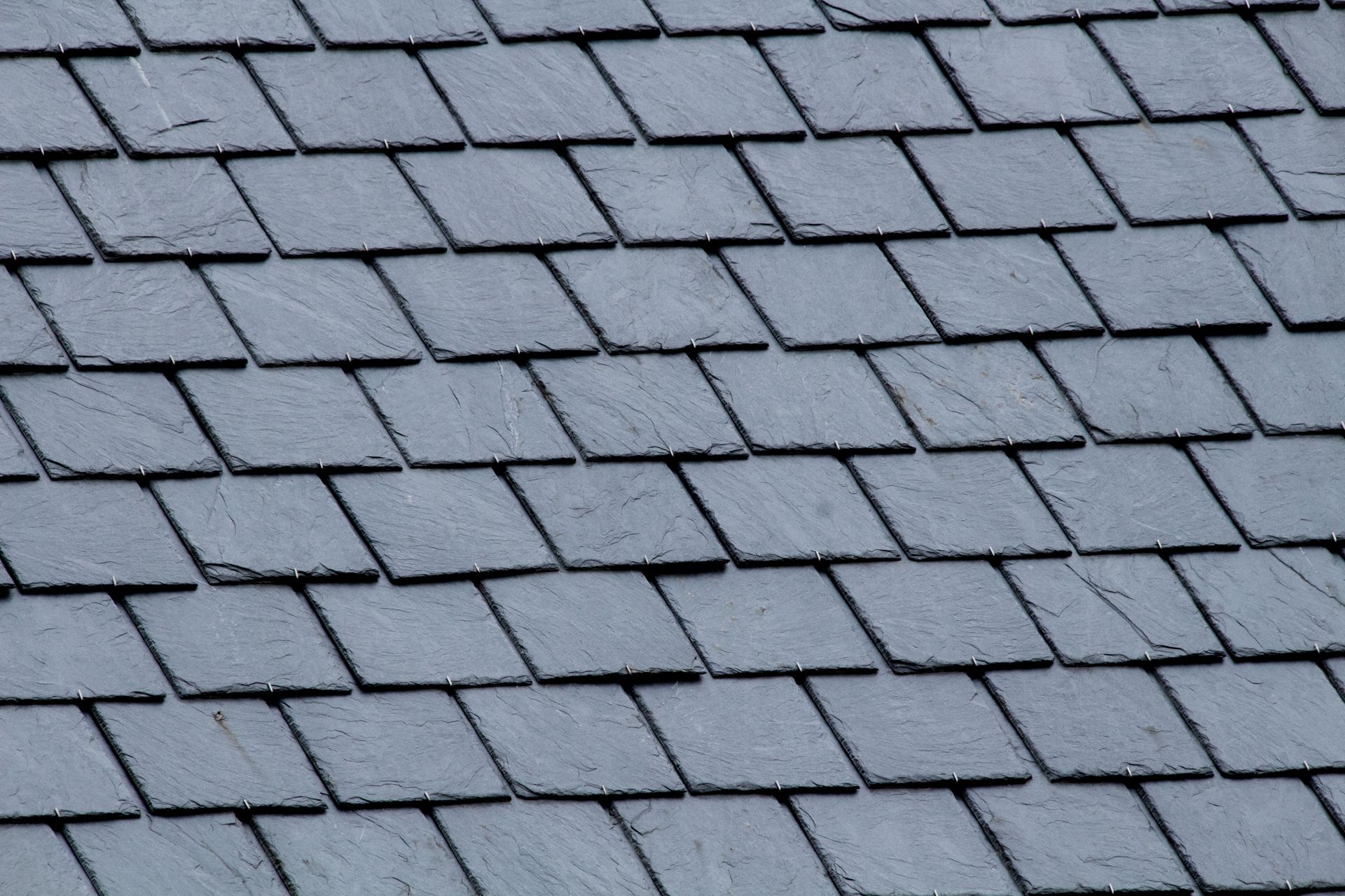 Gray slate roof shingles arranged in neat overlapping rows