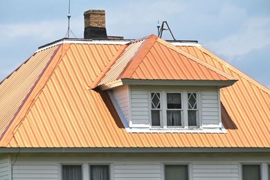 Orange metal roof with dormer windows on a house