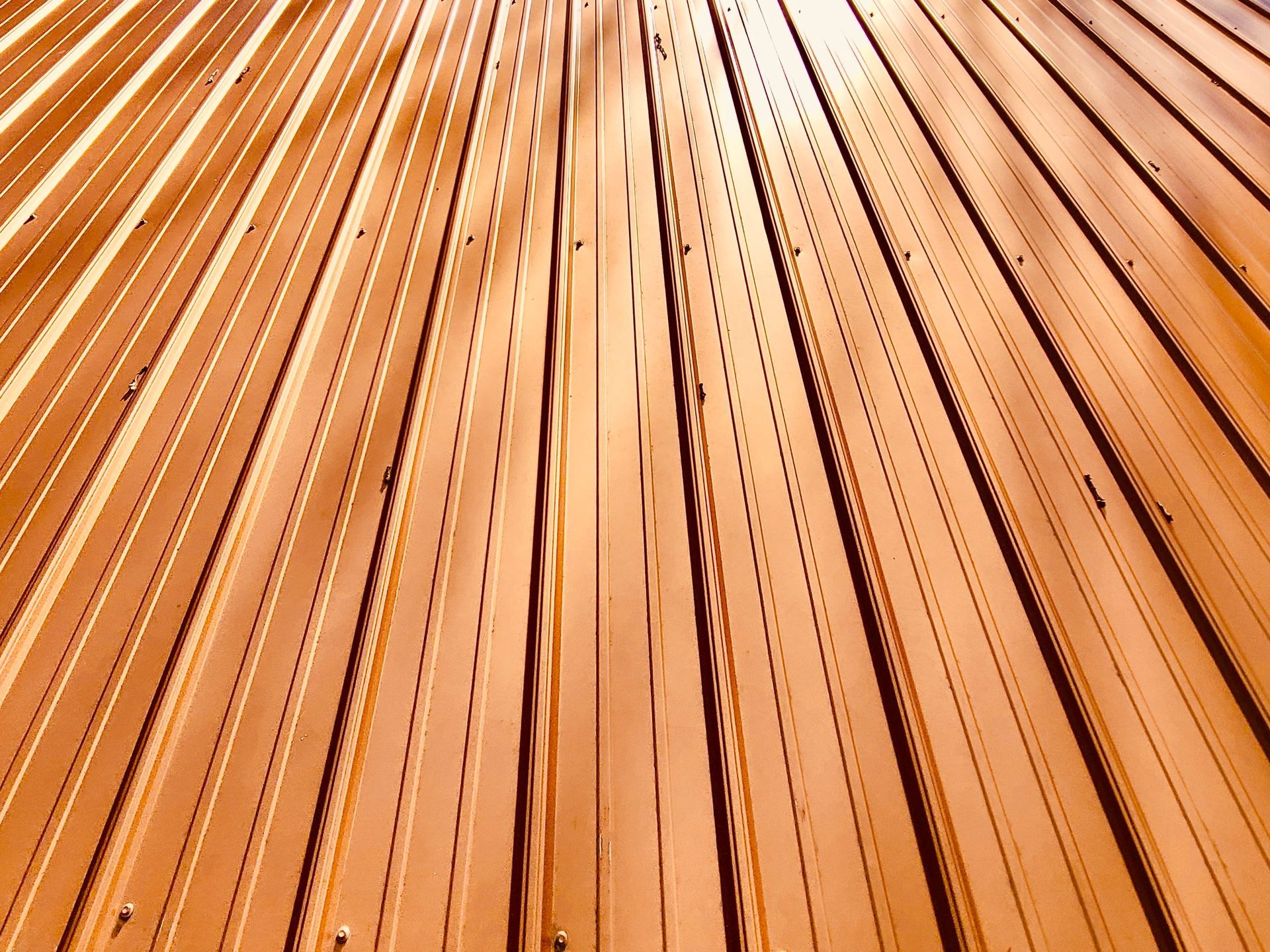 Close-up of orange-brown wooden slats radiating upward in a geometric pattern