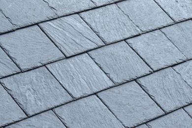 Close-up of gray slate roof shingles arranged in overlapping rows
