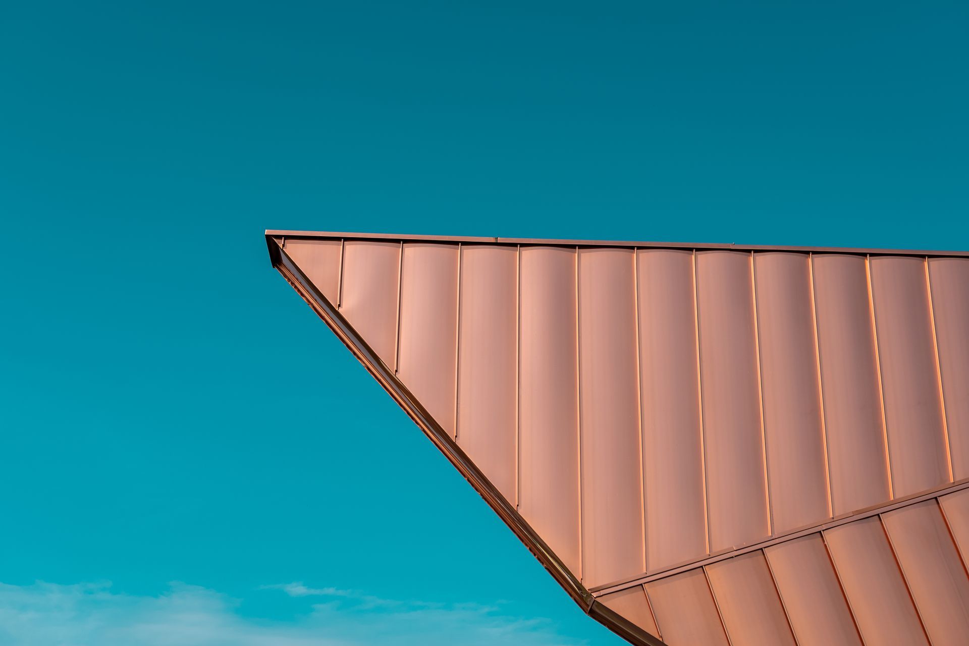 Copper geometric roof against a bright blue sky
