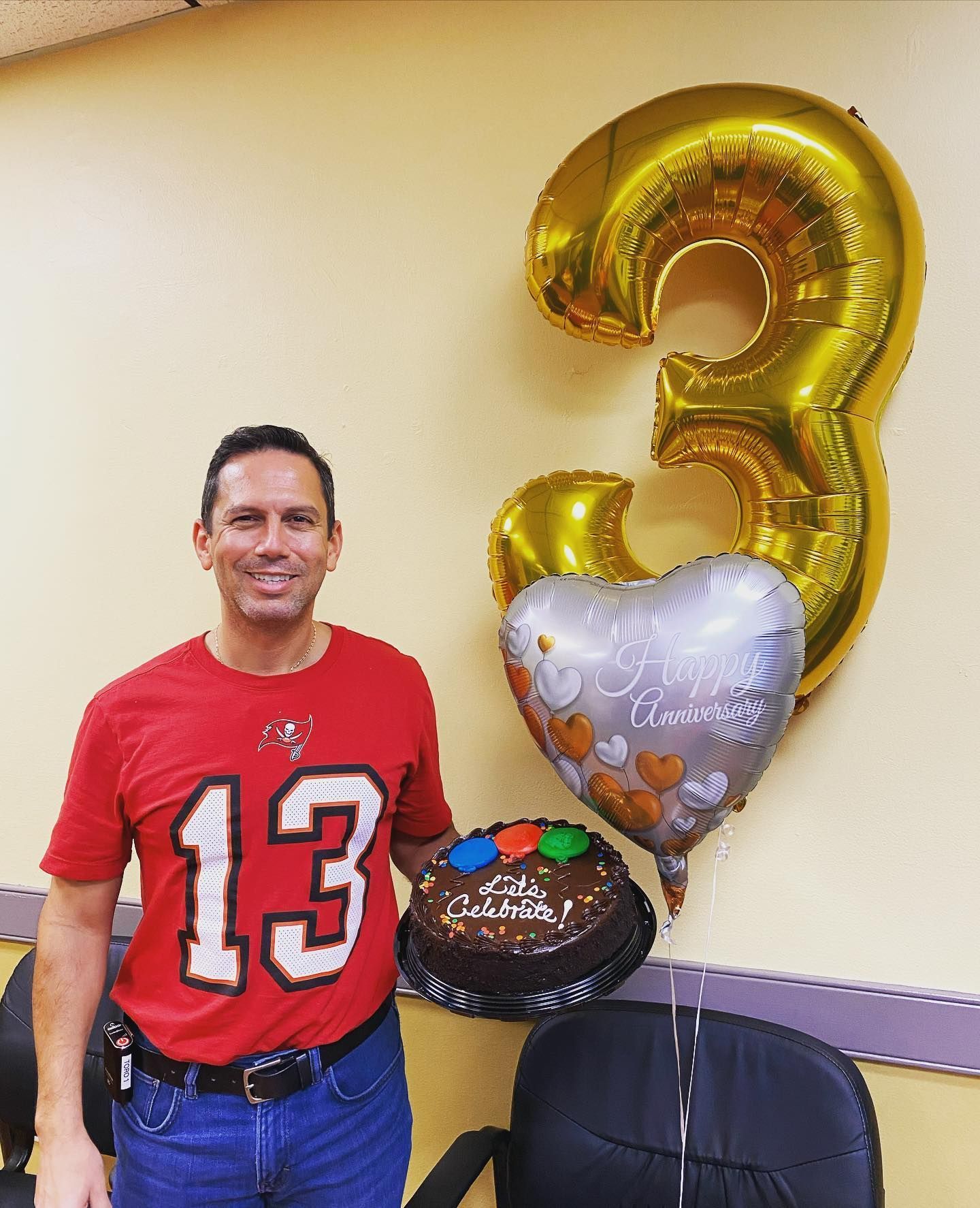 A man in a red shirt with the number 13 on it