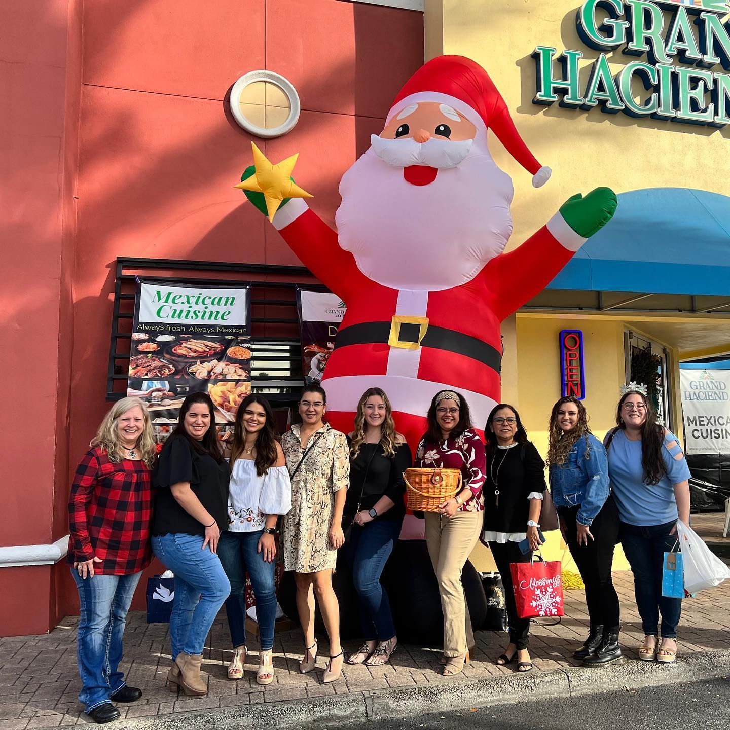 A group of people standing in front of a large inflatable santa claus.