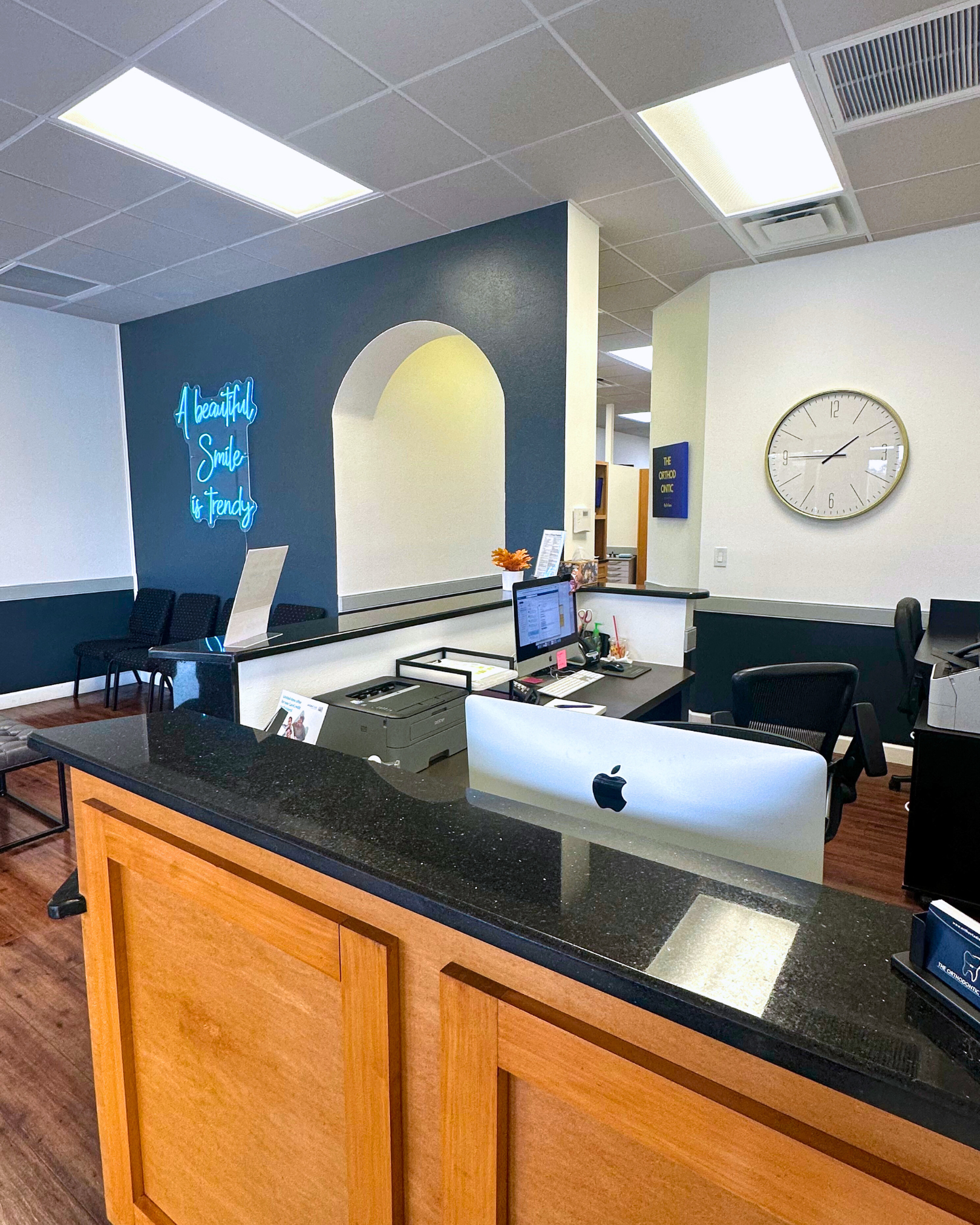 Reception area with a desk, clock, and blue accent wall.