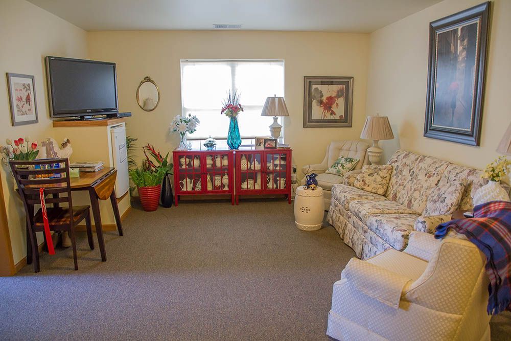 A living room with a couch , chair , table and television.