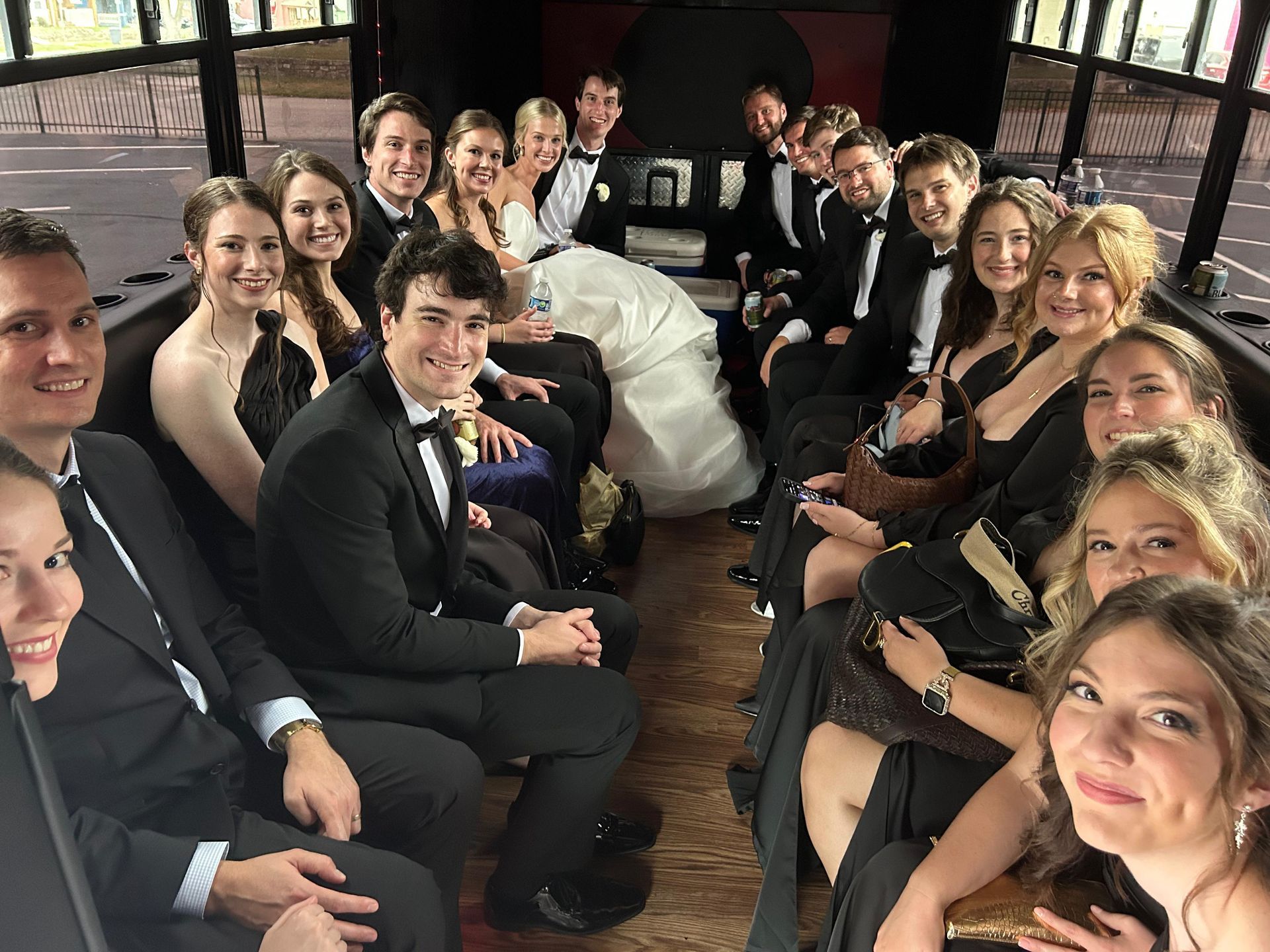 Group of people in formal attire seated at a long table, smiling in a warmly lit indoor setting.