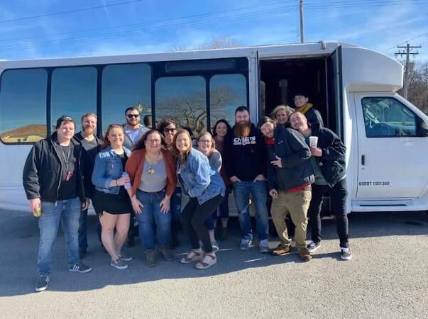 Group of customers standing beside the white party bus