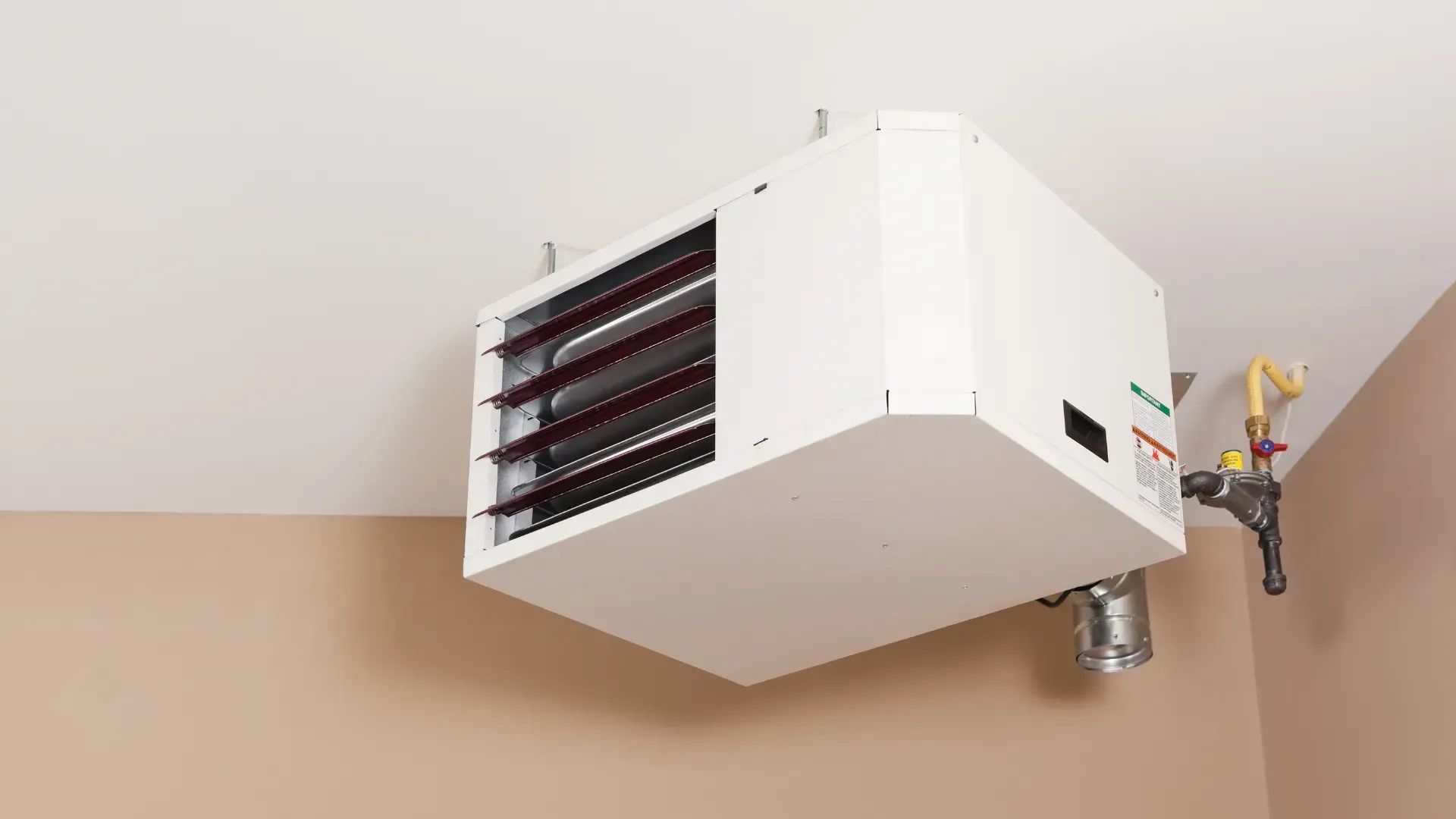 White overhead garage heater against a beige wall and white ceiling.