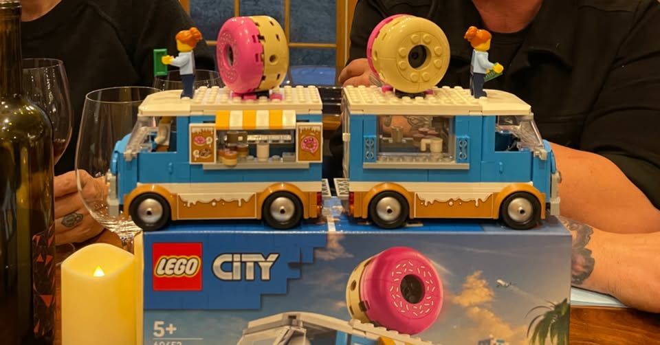 Two LEGO donut food trucks, each with a large donut on top.  A box is in front.