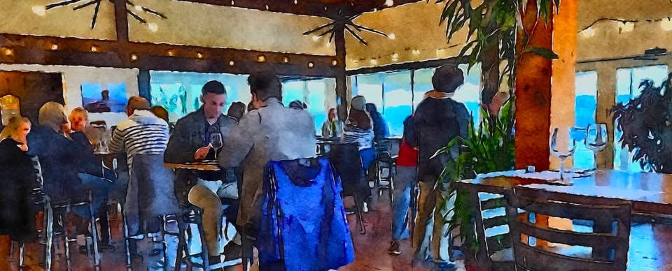 People seated at tables in winery with large windows.