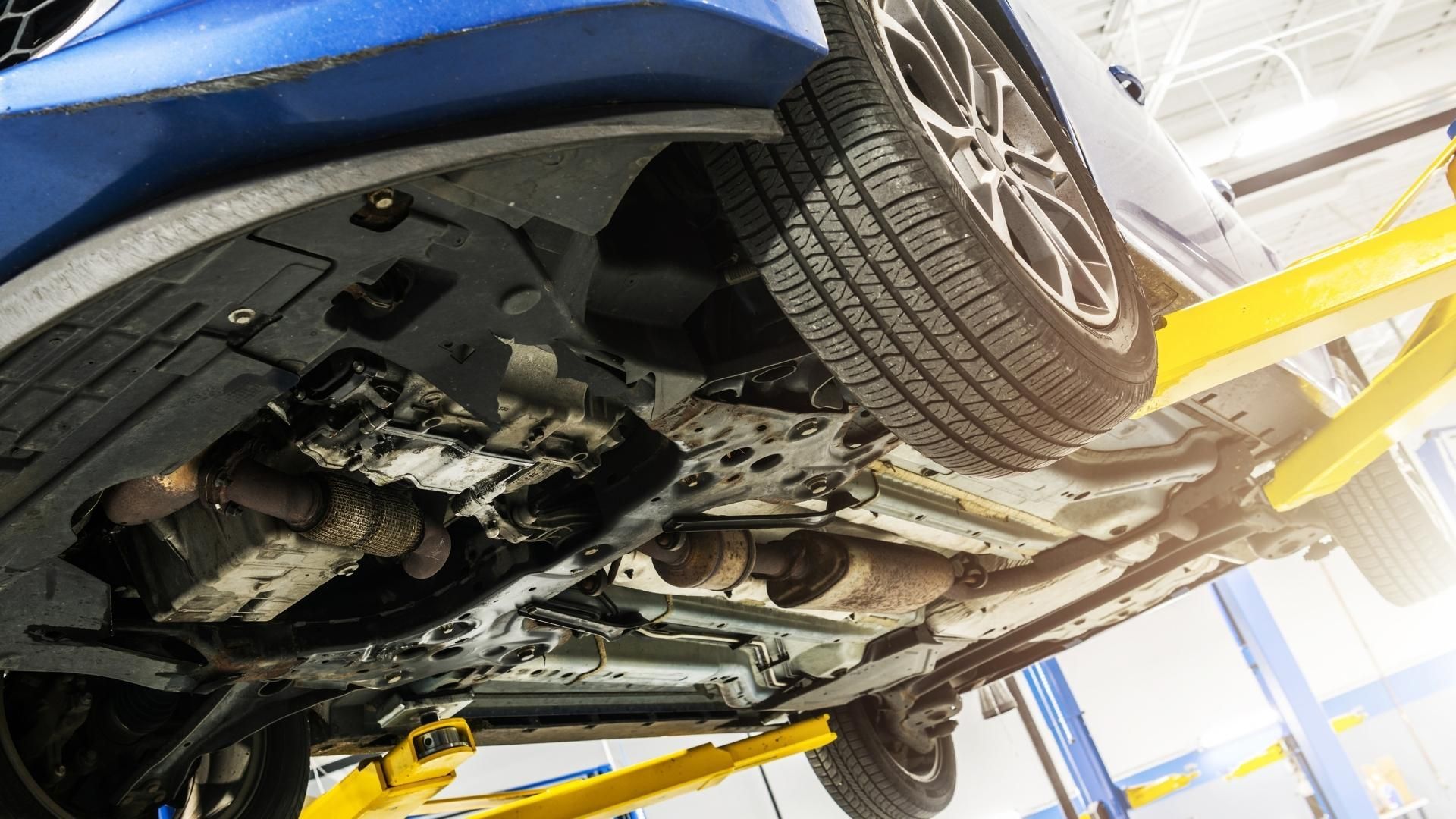 A blue car is sitting on a lift in a garage.