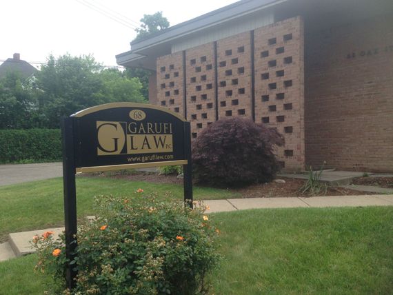 A sign for garifi law is in front of a brick building
