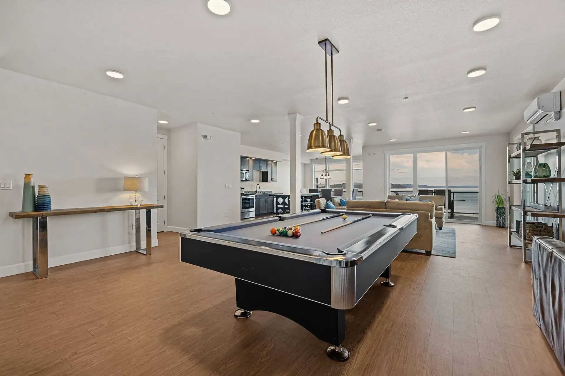 Billiards table in a modern common area with kitchen and ocean view