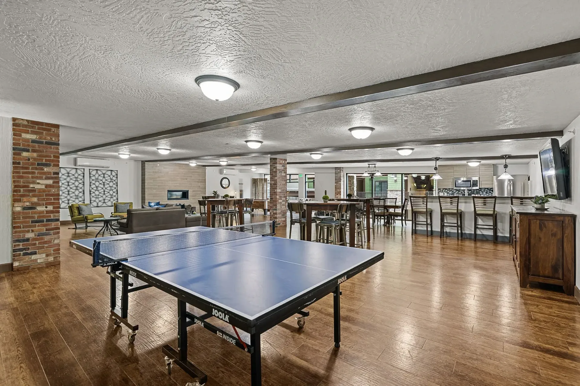 Community lounge area with ping pong table, seating, and a bar.